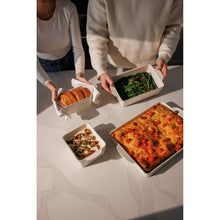 Cream ceramic bakeware set with four dishes filled with baked entrees