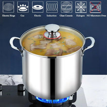 Stainless steel stock pot with glass lid, filled with soup over heat burner
