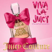 Perfume bottle with magenta bow and ornate gold pendant label on clear glass