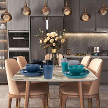 Wheat straw dinnerware set stacked on a table with blue and gray plates and cups