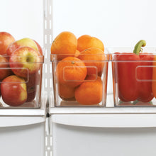 Clear refrigerator organizer bin with front handle opening holding fruit and produce.