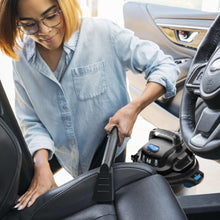 Wet/dry vacuum nozzle and hose cleaning a car seat