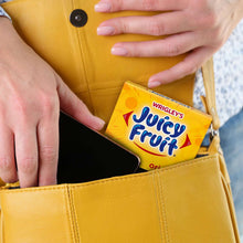 Juicy Fruit Original gum pack partly in a yellow pocket, held by hands