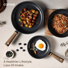 Black nonstick saute pan with wooden handle, filled with cooked ingredients