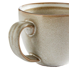 Stoneware mug close-up of speckled cream handle and side with brown rim