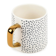 14 fl oz dot stoneware mug with off-white finish, black speckle pattern, and gold-tone side handle