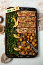 Garlic and herb butter stick carton on meal tray with pork, greens, and roasted potatoes