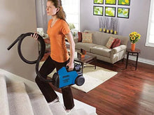 Blue canister vacuum cleaner being used with hose handle and wand