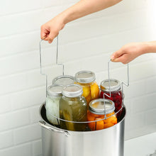 Jar rack lifting multiple filled canning jars from a stainless steel canner