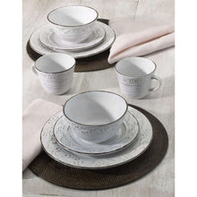 White stoneware place setting with layered plates, bowls, and mugs