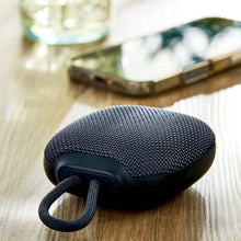 onn mini rugged speaker on wood, dark gray fabric with loop handle