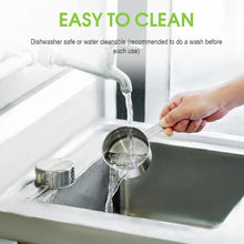 Stainless steel measuring cup being rinsed with running water in a sink