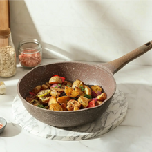 Brown speckled nonstick skillet with wood handle filled with roasted vegetables
