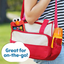 Red Elmo learning phone attached to a red bag with white eyes and orange nose