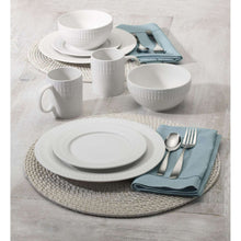 Porcelain dinnerware set with plates, bowls, and mugs on table setting