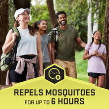 Insect repellent spray bottle held outdoors, green sprayer