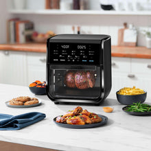 Black air fryer oven on countertop with viewing window showing roasted food