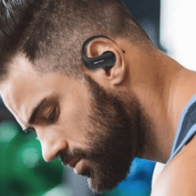Wireless earphone worn by a man with a short beard