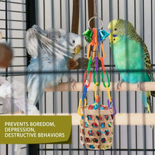 Colorful hanging bird chew basket toy with woven material and dangling rope strands.