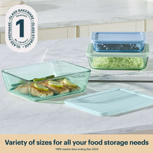 Tinted rectangular food storage containers with blue and green lids, set on counter