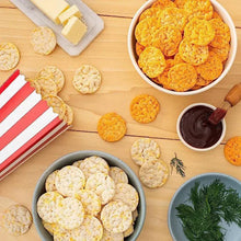 Cheddar rice crisps in bowls and scattered crackers with dipping sauce