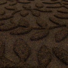Brown leaf-vine doormat surface close-up with textured pile pattern
