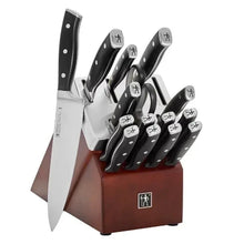 Knife block set with black-handled knives and one large chef knife pulled forward