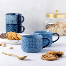 Blue patterned ceramic mugs with curved handles, two shown
