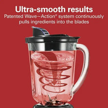 Glass blender jar with black lid and base, with pink smoothie-like blend