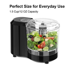Black electric food chopper with clear bowl filled with chopped vegetables