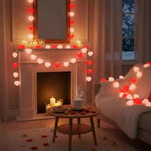 Heart-shaped string lights across fireplace mantel, glowing red and pale hearts