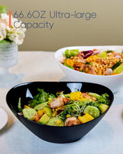 Black ribbed salad bowl filled with greens, cucumber, and shrimp