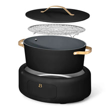 Electric multi-cooker with black pot, lid, steaming rack insert, gold side handles