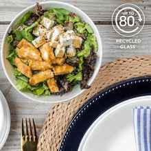 White glass dinner bowl with salad and plate beside it