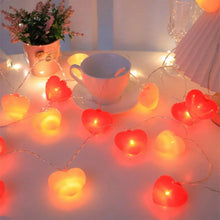 Heart-shaped string lights with glowing red and pink hearts, close-up