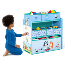 Blue children's toy storage organizer with fabric bins and character front; child reaching