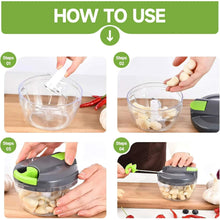 Manual food chopper with green lid on clear bowl, shown in use for chopping