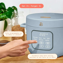 Cornflower blue rice cooker on countertop with front touch display and program buttons