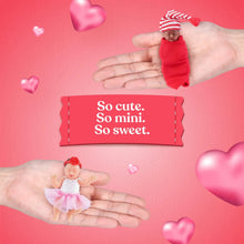 Mini baby doll figures held in hands, small red-dressed baby and pink outfit baby