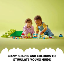 LEGO DUPLO building bricks on a play surface with two children at work