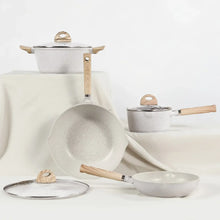 Cookware set with speckled pots and pans, glass lids, and wood-look handles