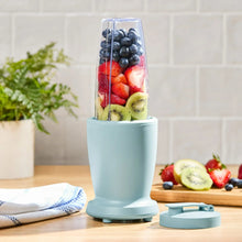 Blue blender base with clear jar filled with blended fruit and teal lid