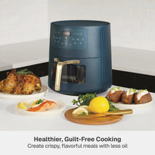 Atlantic Blue air fryer with gold handle, beside plated food