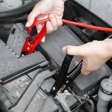 Booster cable clamps being attached to a battery terminal using red and black leads