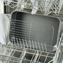 Gray roasting pan with removable rack loaded in a dishwasher