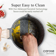 Black speckled nonstick saucepan being cleaned with a hand brush