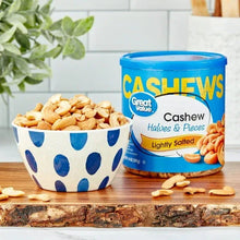 Cashew halves and pieces in a bowl next to lightly salted cashew tub