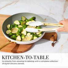 White and gold silicone spatula and tongs set, shown stirring food in a pan
