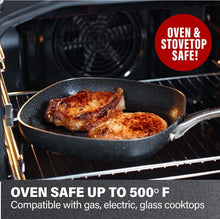 Square nonstick fry pan in oven with seared food, speckled dark interior and handles.