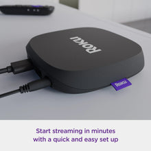 Black streaming player connected with HDMI and power cables